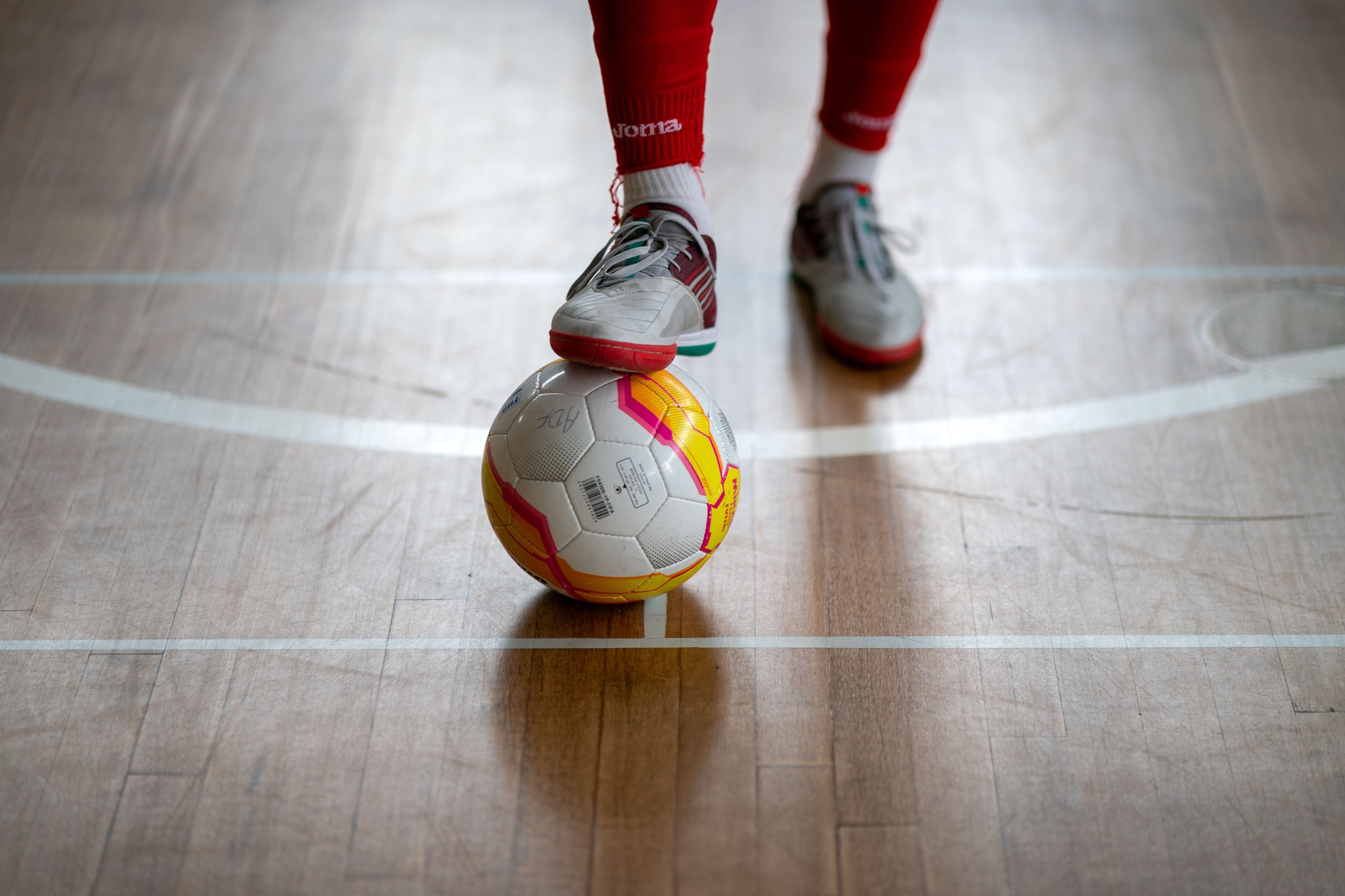 Atletas de futsal em ação durante jogo profissional